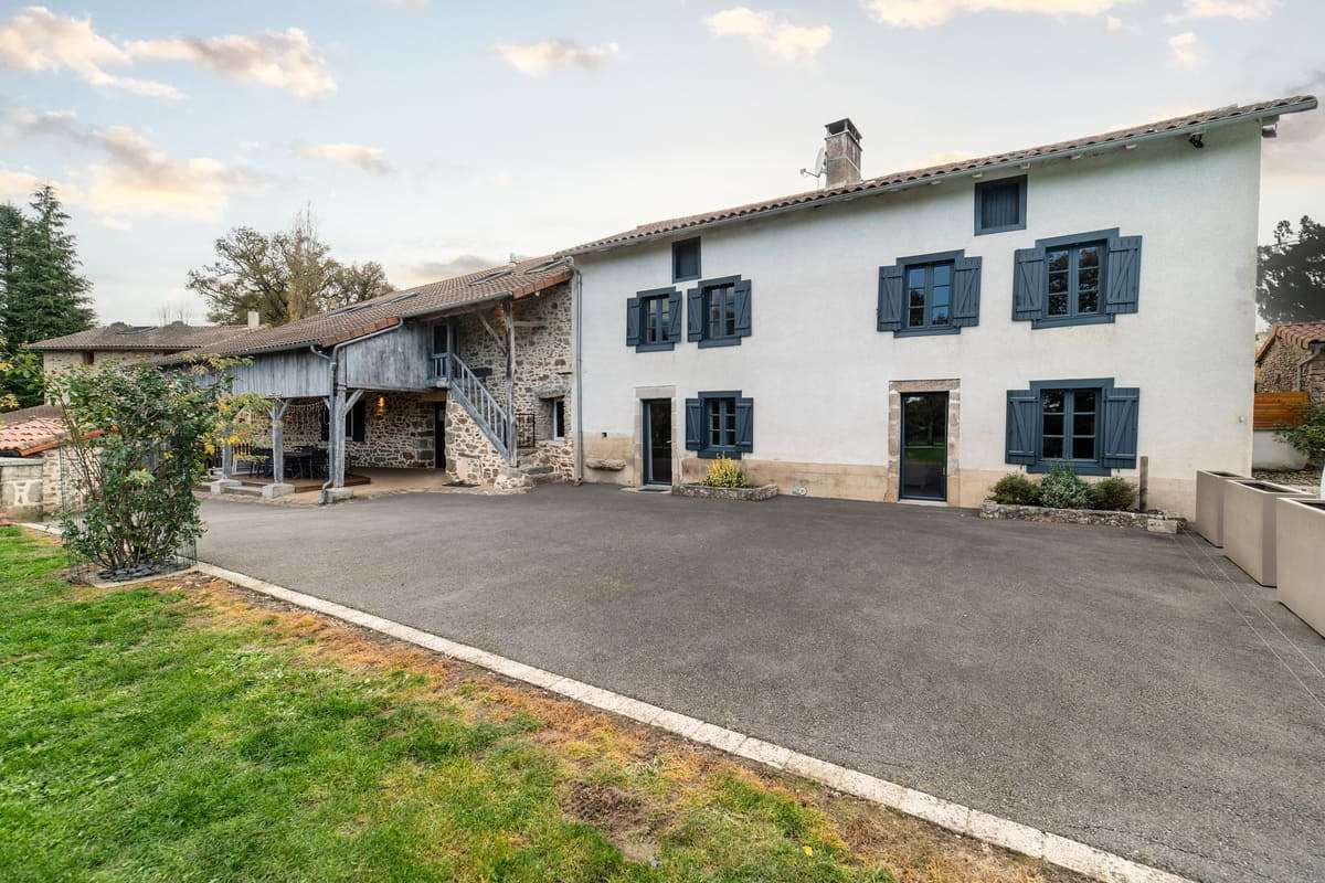 Façade en pierre du Domaine la Roche et sa cour privative en Haute-Vienne