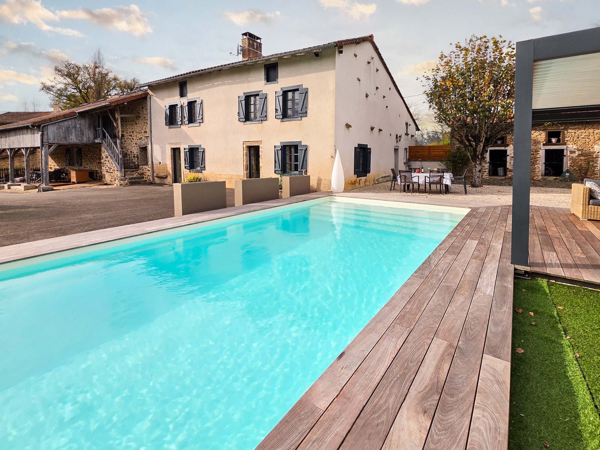 Façade en pierre du Domaine la Roche et sa piscine extérieure chauffée
