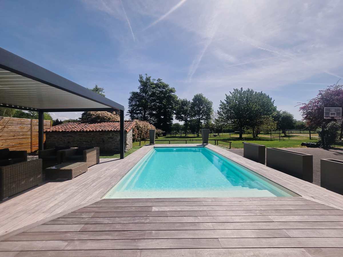 Piscine extérieure chauffée du Domaine la Roche, bordée de sa pergola