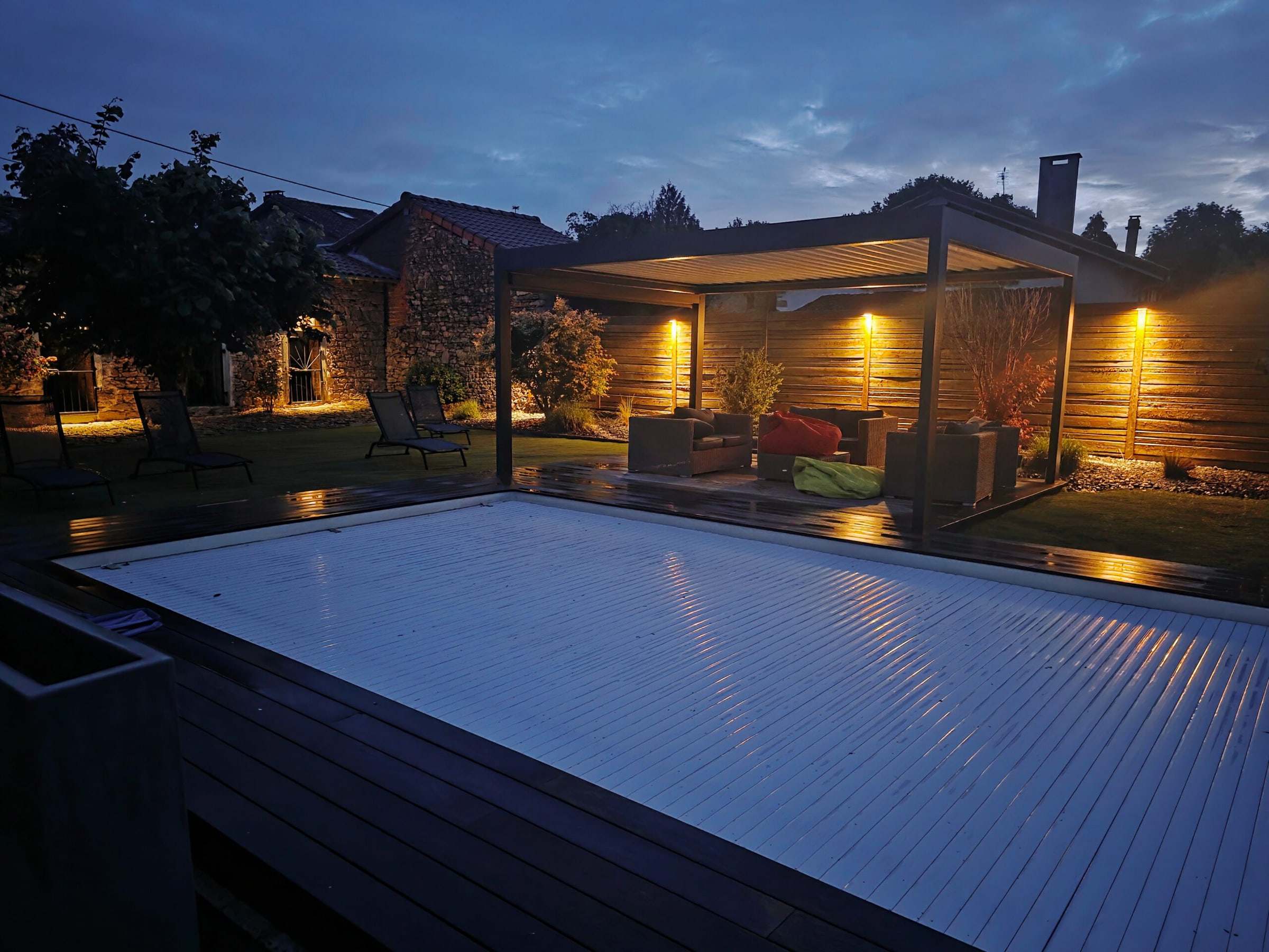 Piscine et pergola éclairées au crépuscule