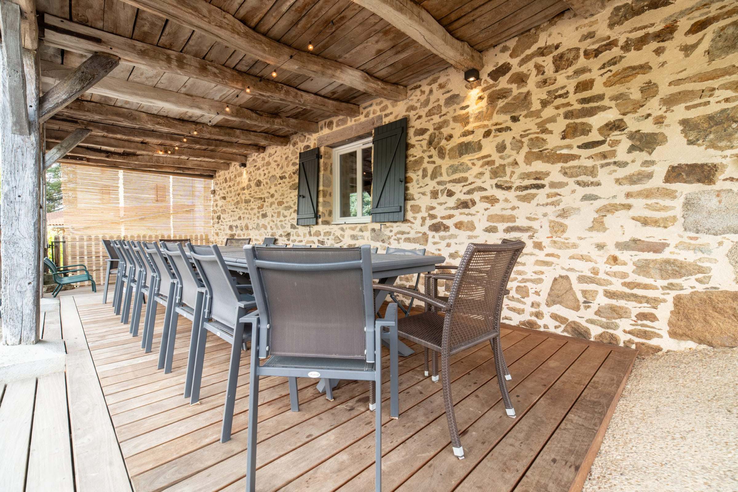 Terrasse couverte en pierre dressée pour un repas de groupe