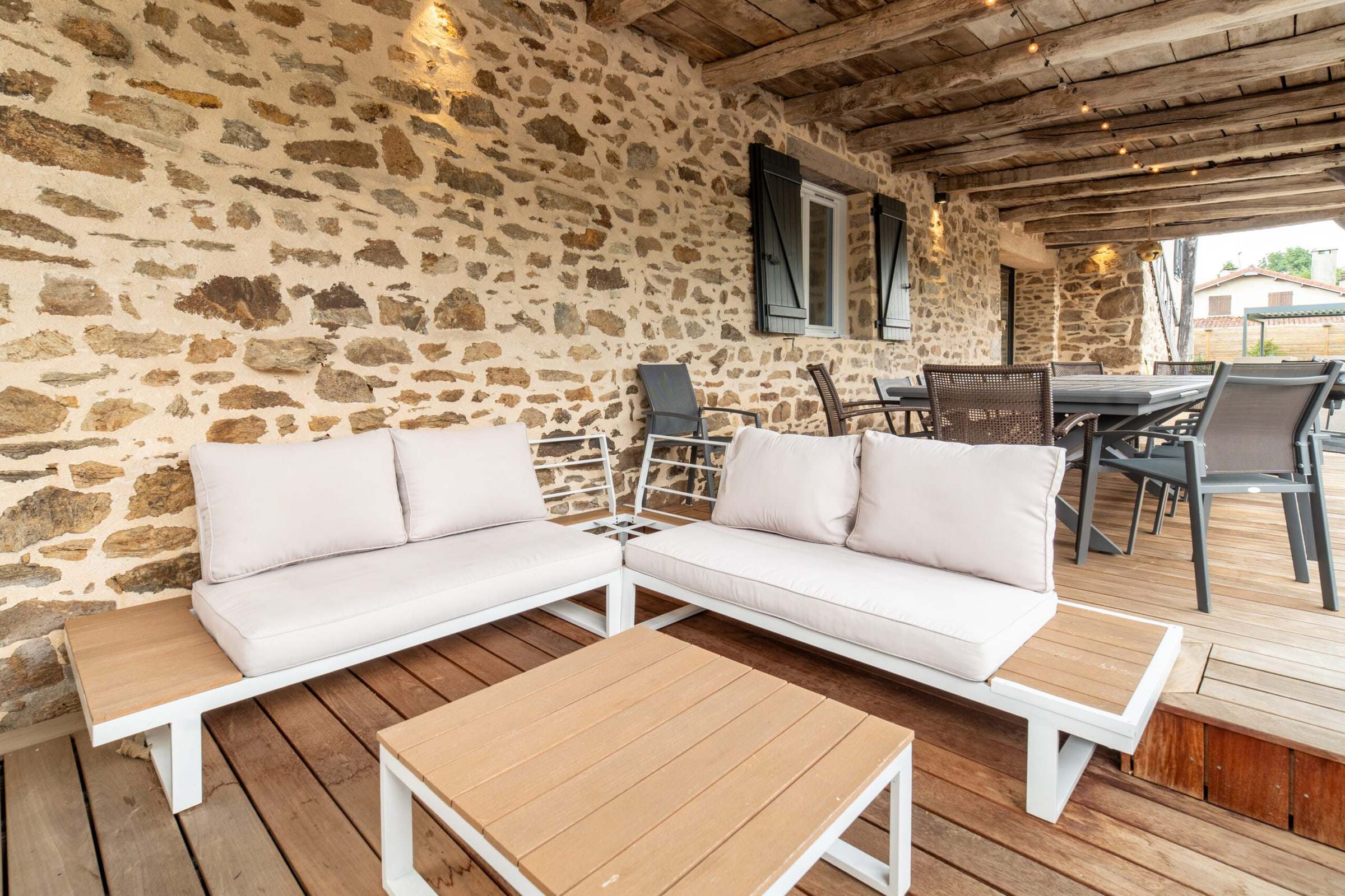 Salon de jardin sous la terrasse couverte en pierre