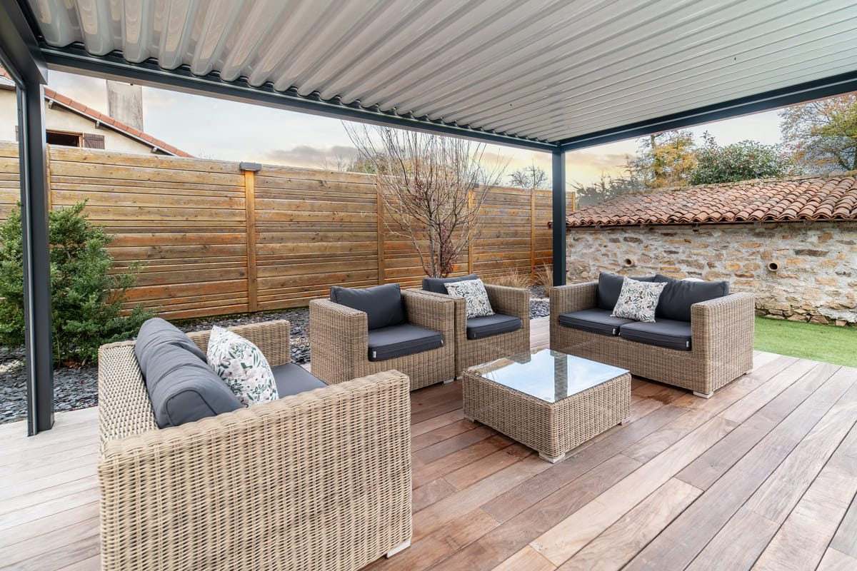 Pergola bioclimatique et son salon de jardin en résine tressée