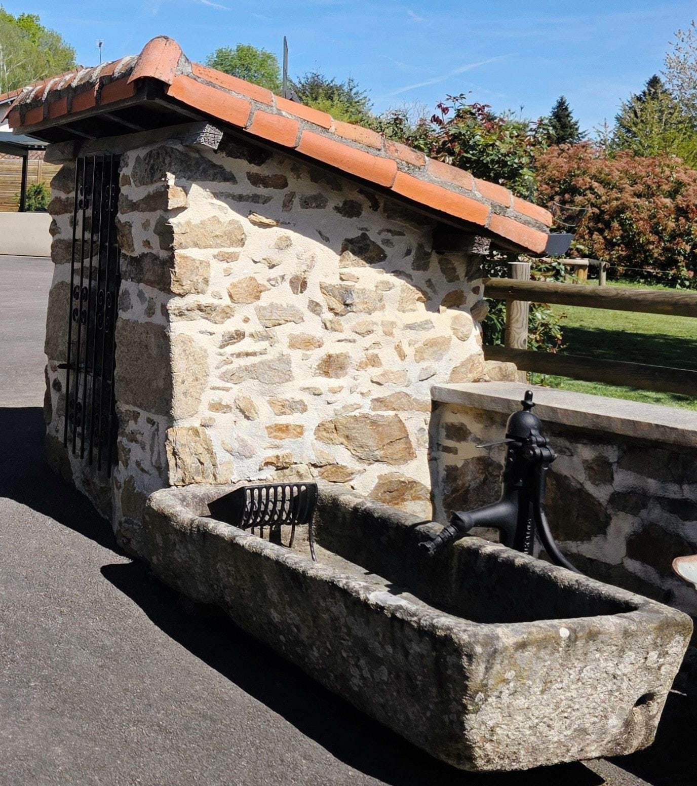 Ancien lavoir en pierre conservé dans le parc du Domaine la Roche