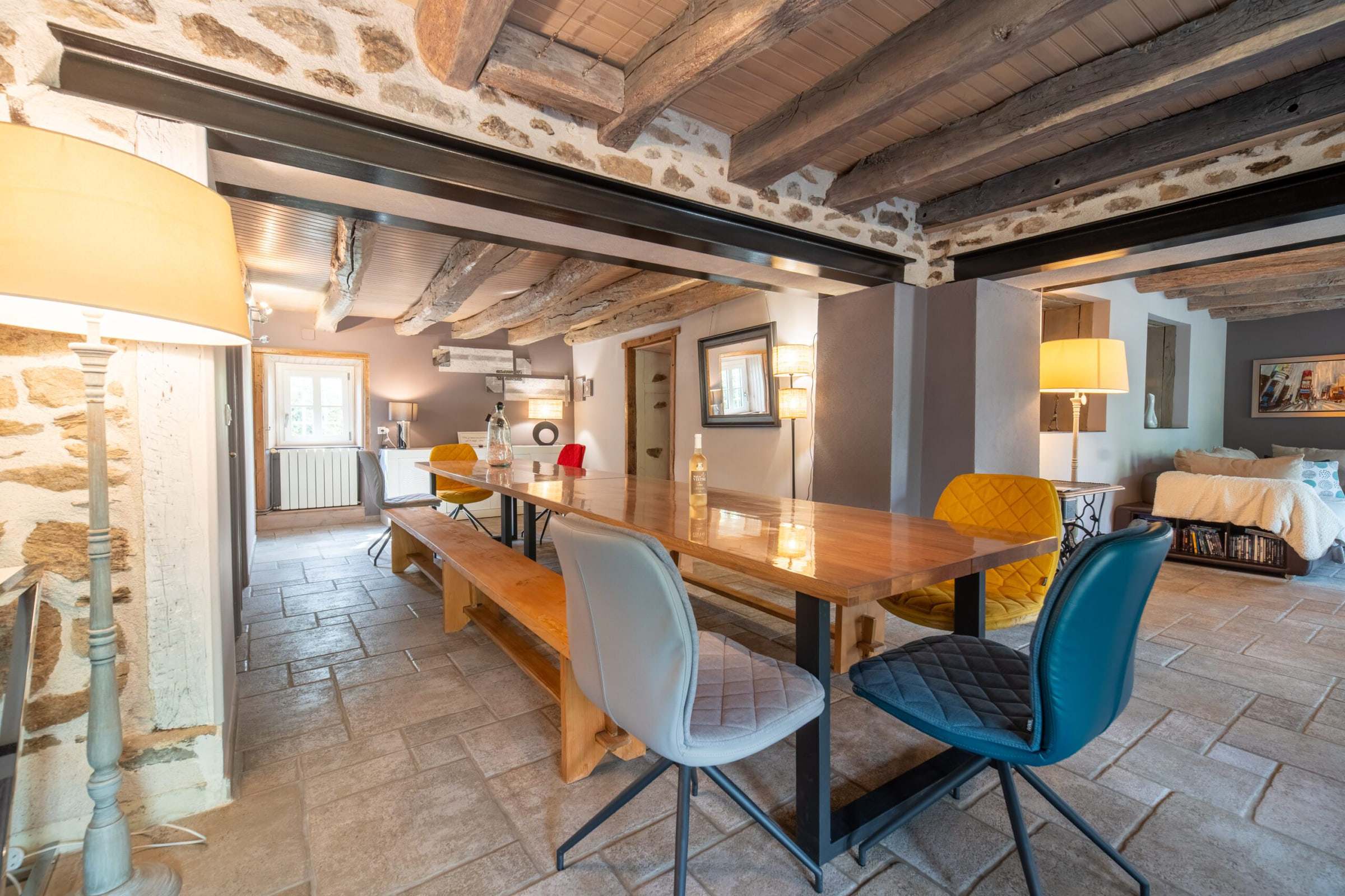 Grande salle à manger sous poutres apparentes avec table de 20 couverts