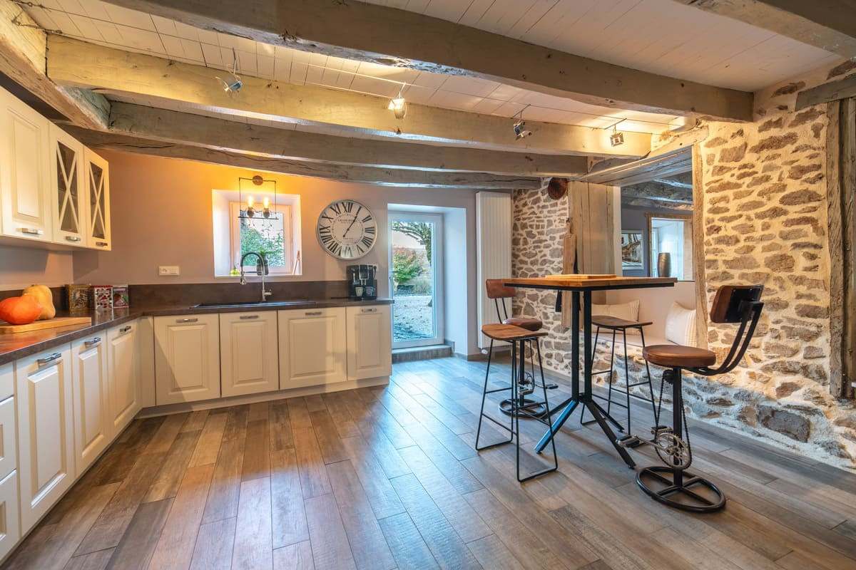 Coin bar et tabourets hauts devant un mur en pierre apparente