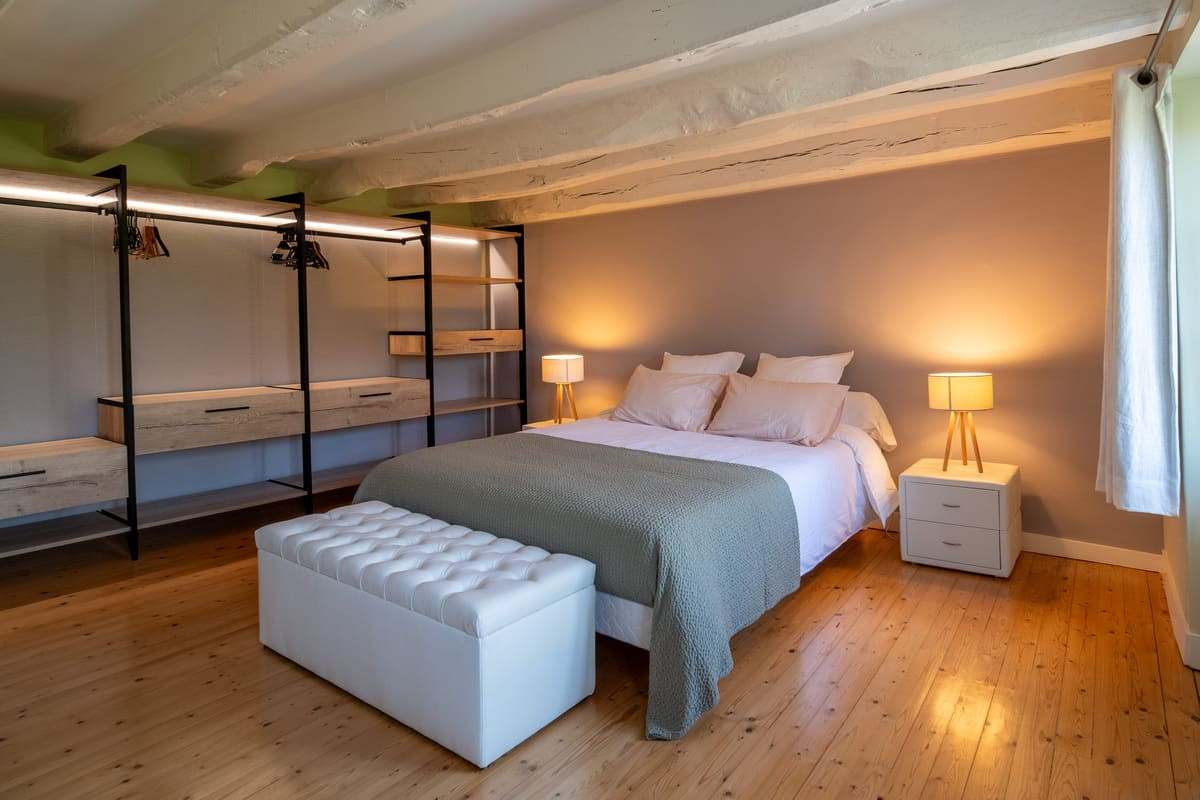 Chambre avec lit double, banc capitonné et étagère métal