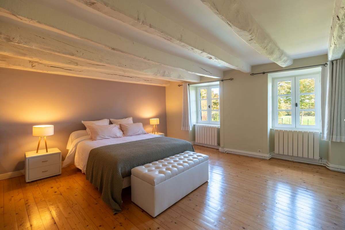 Chambre lumineuse avec lit double et banc de lit