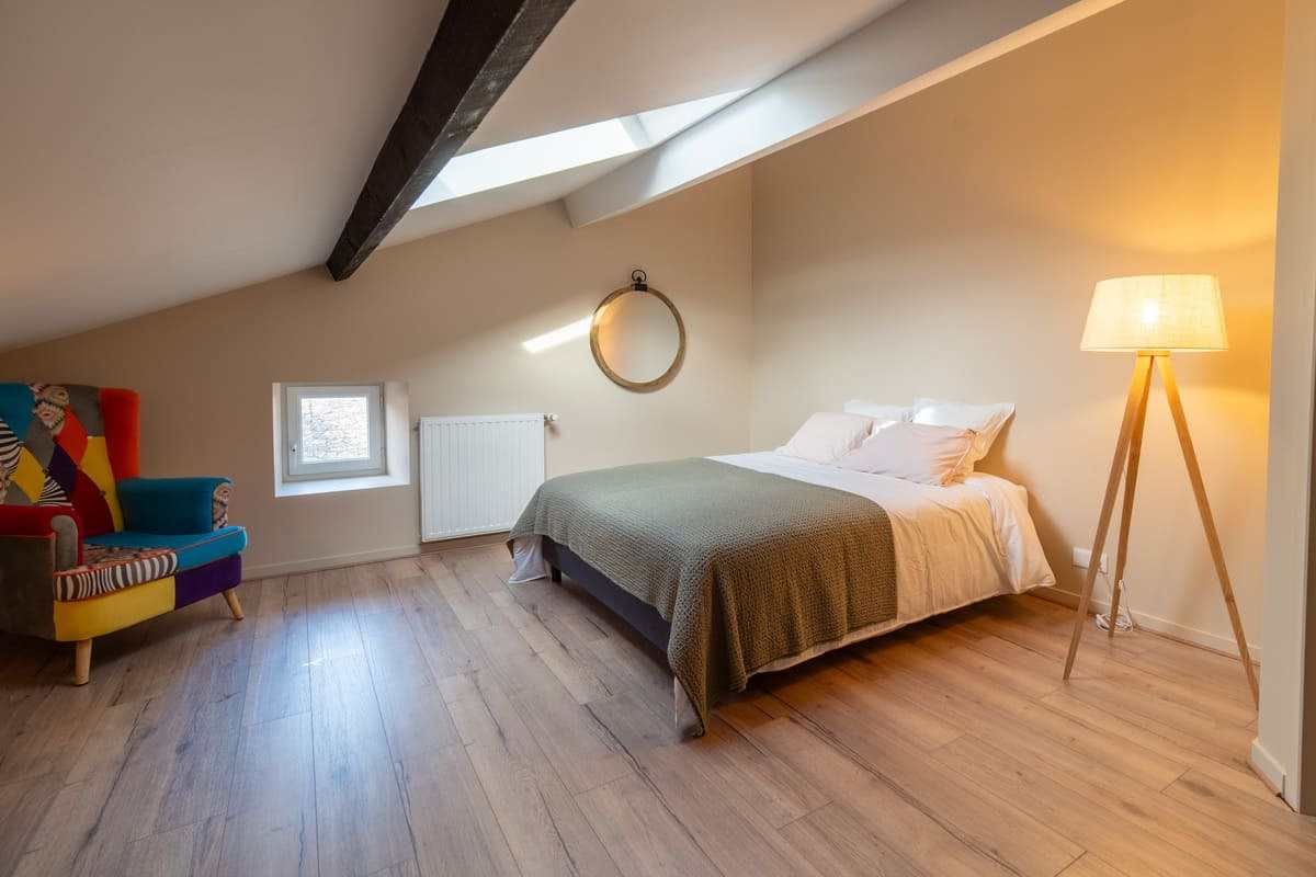 Grande chambre confortable avec literie de qualité et banc de lit