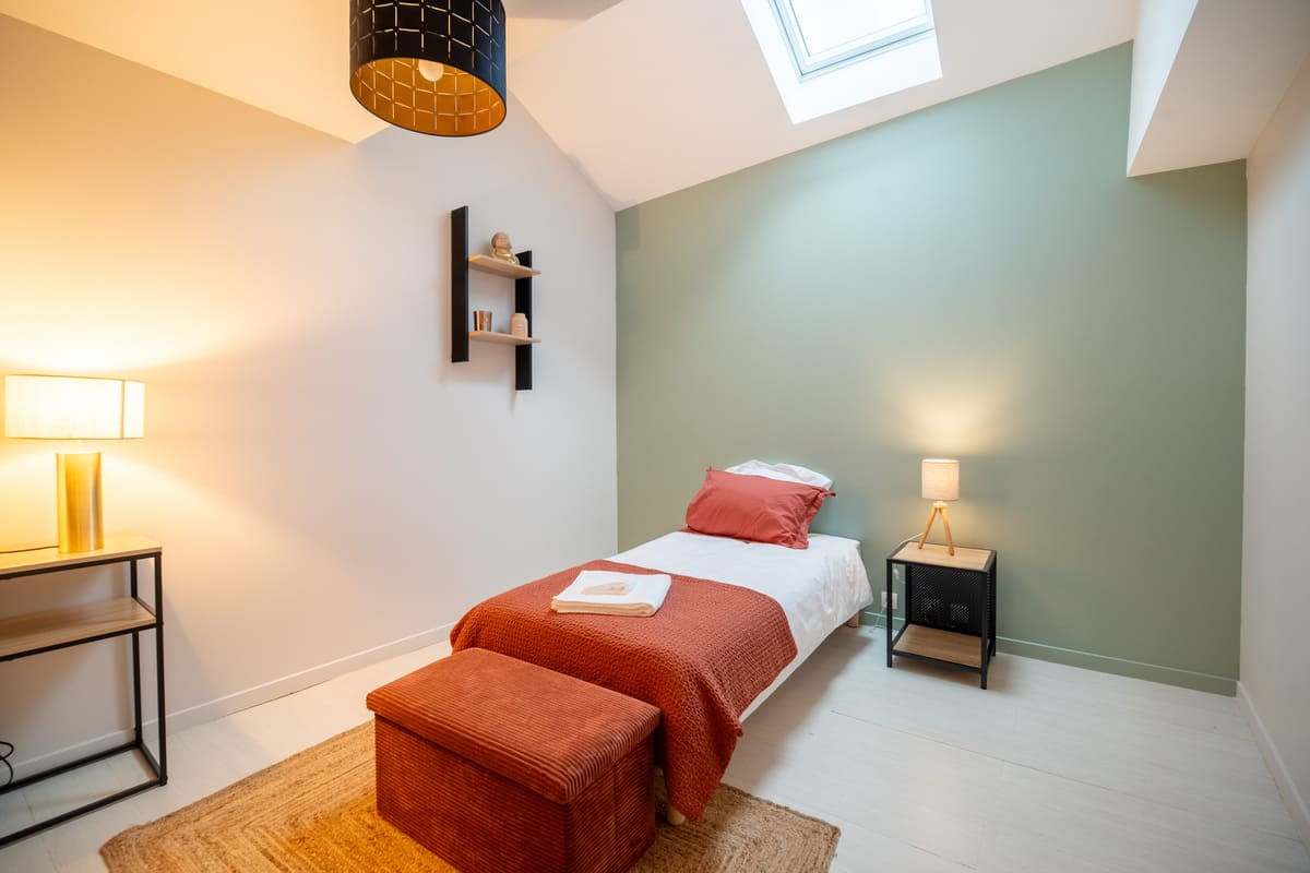 Chambre enfant au mur vert d’eau avec lit simple