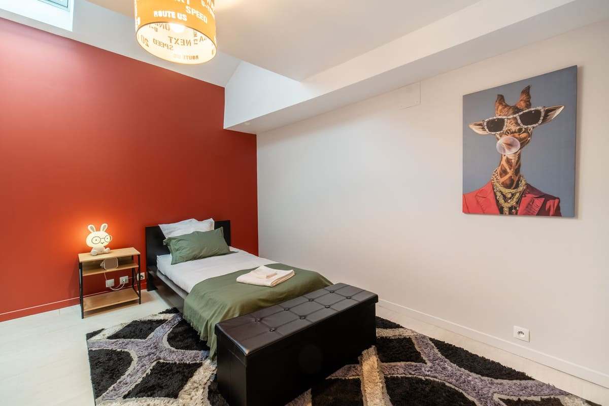 Chambre enfant au mur rouge avec lit simple