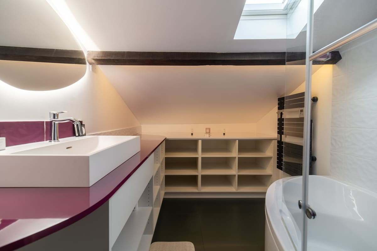 Salle de bain sous combles avec double vasque et baignoire